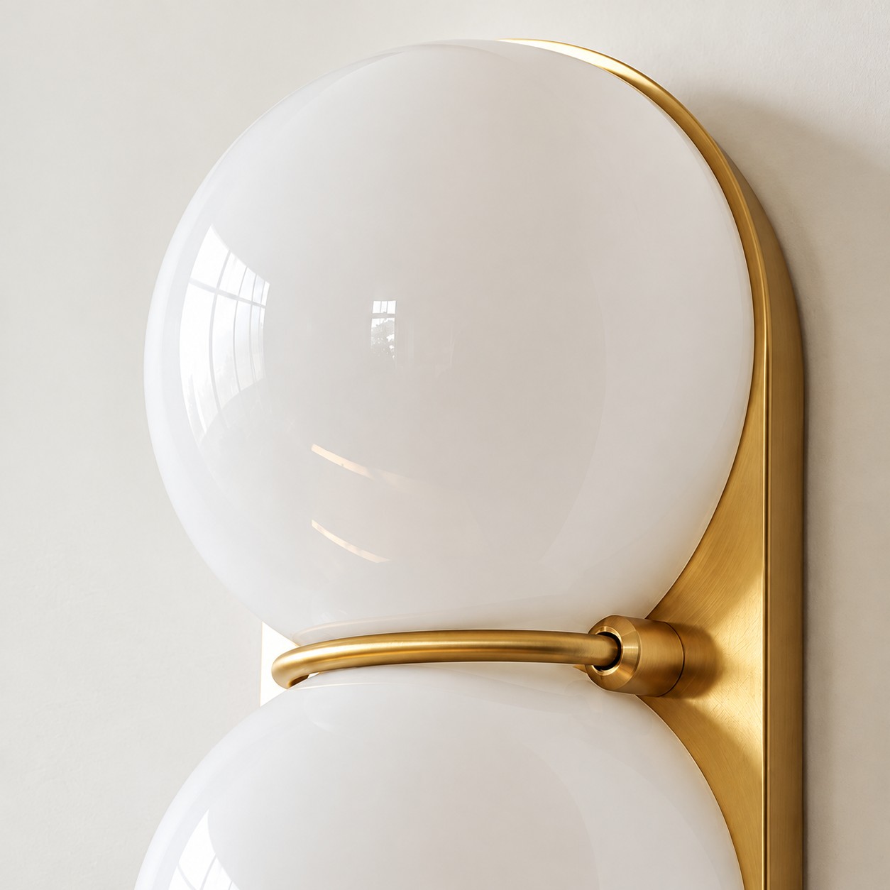 Close view of the brass ring between two white glass globes